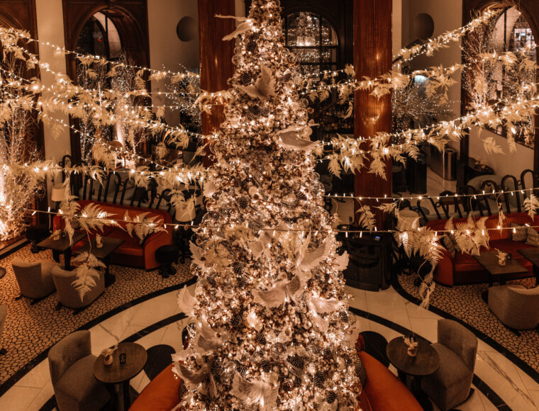 One Aldwych Lobby Bar at night, featuring a glowing Christmas tree at the center, surrounded by elegantly decorated interiors with warm festive lighting and seasonal décor.